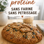 Pain protéiné fait maison sans farine ni pétrissage, posé sur une planche en bois.