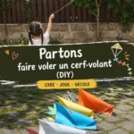 Un enfant souriant tenant un cerf-volant coloré dans un parc, prêt à le faire voler.